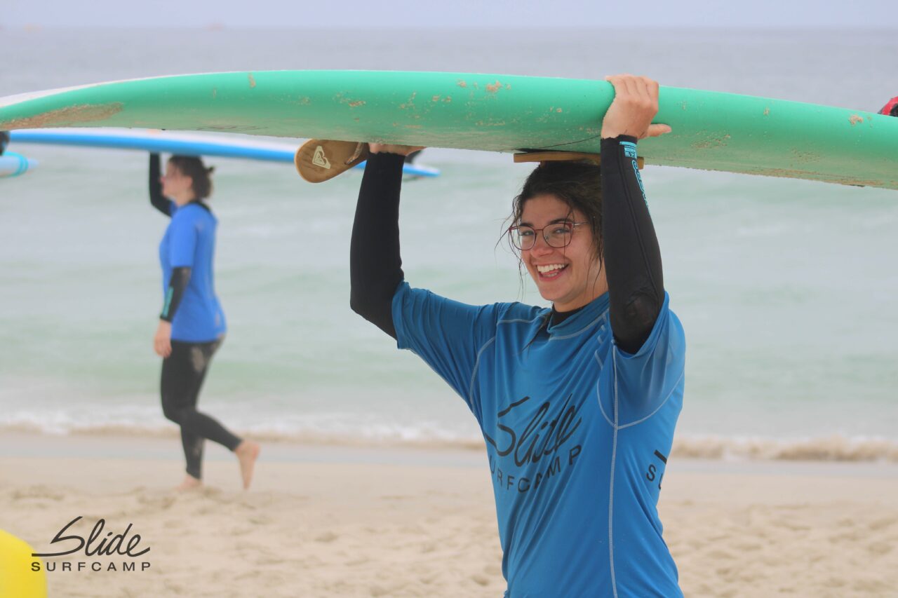 Frau mit Surfbrett am Strand