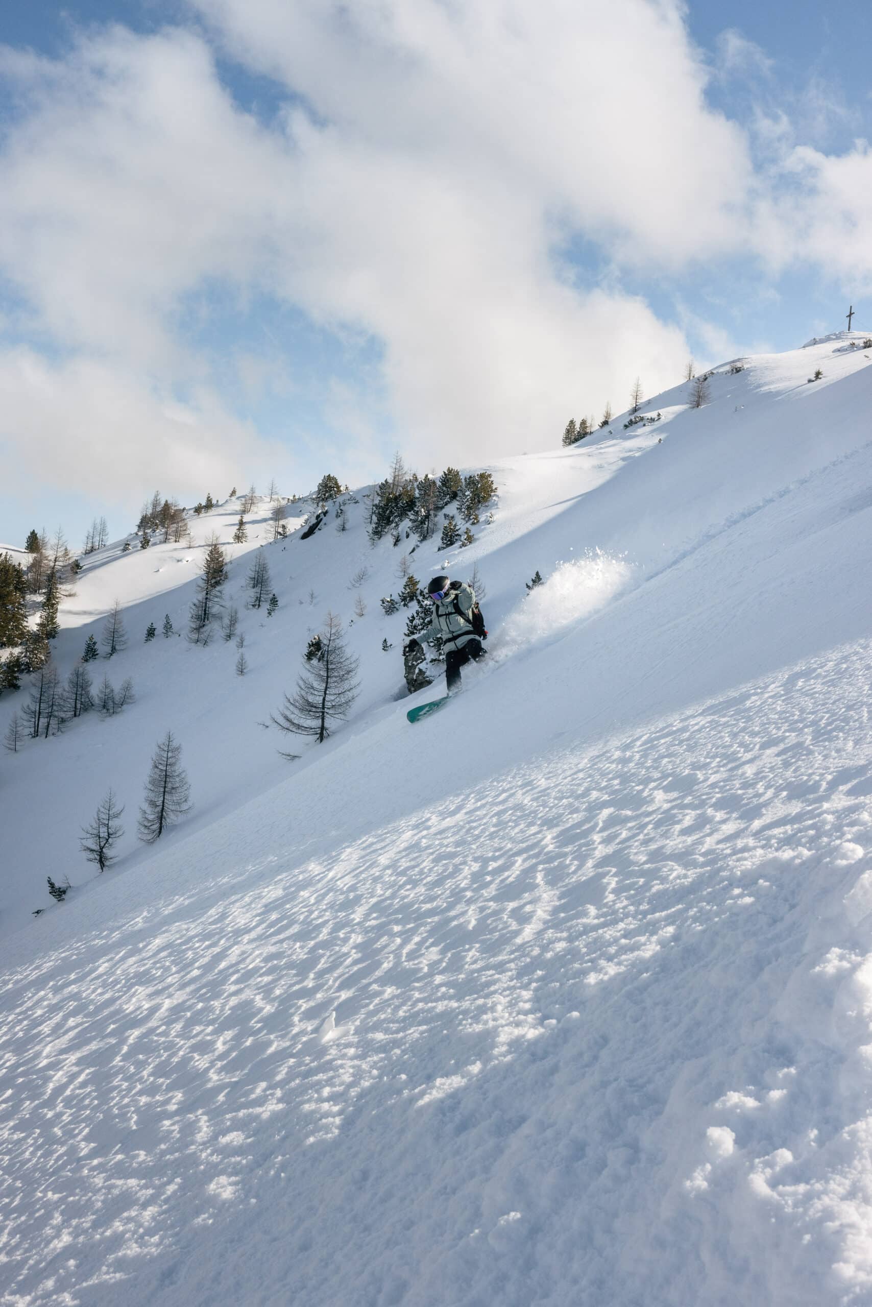 Frau fährt mit dem Splitboard einen Hang