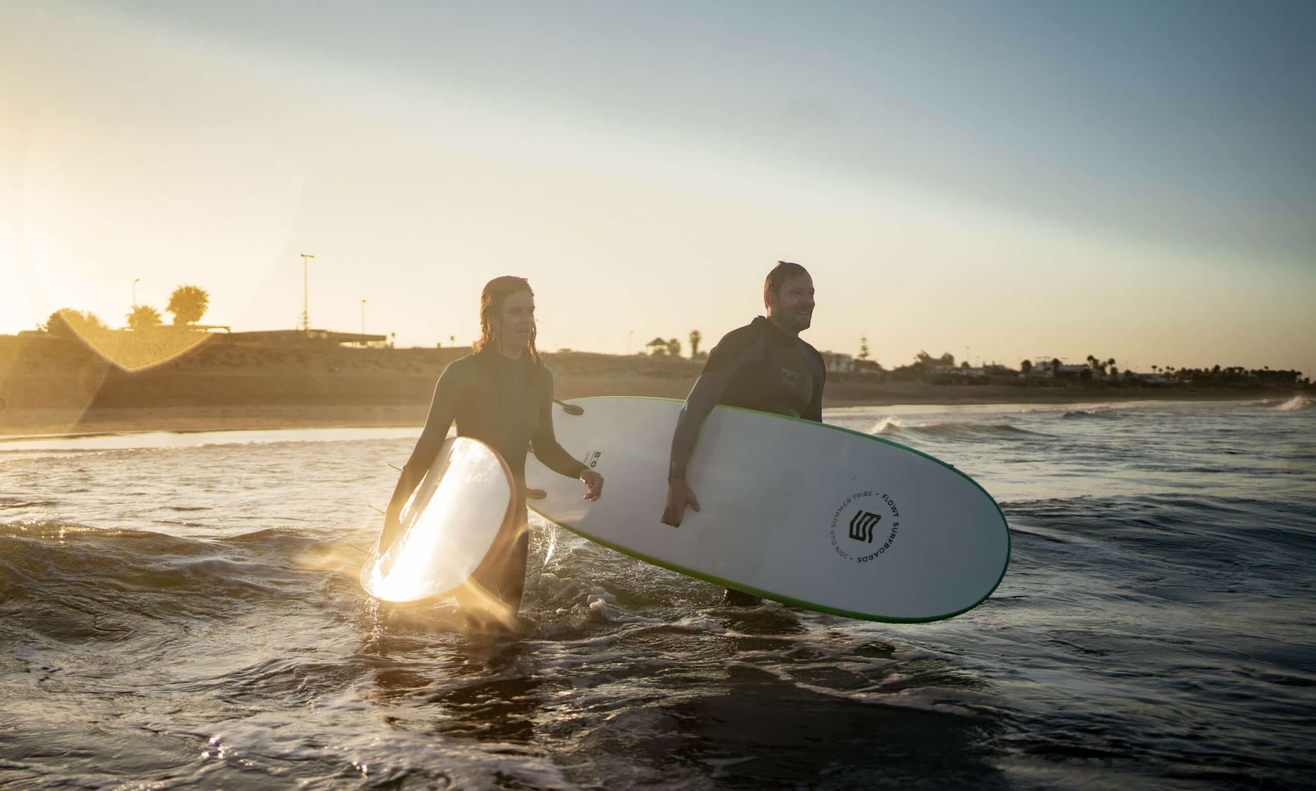 Menschen mit Surfbrett im knietiefen Wasser