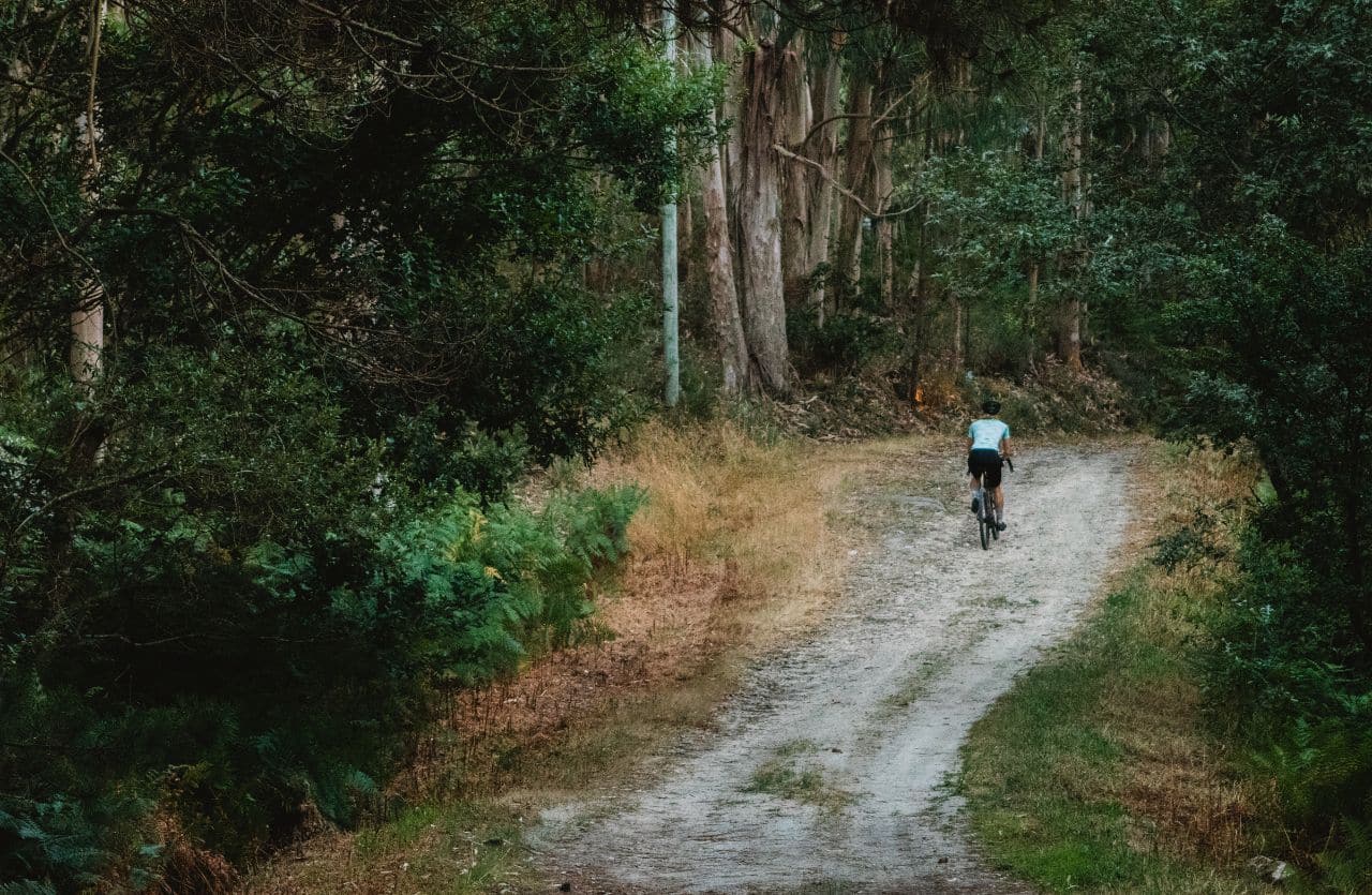 Frau mit Gravelbike im Wald